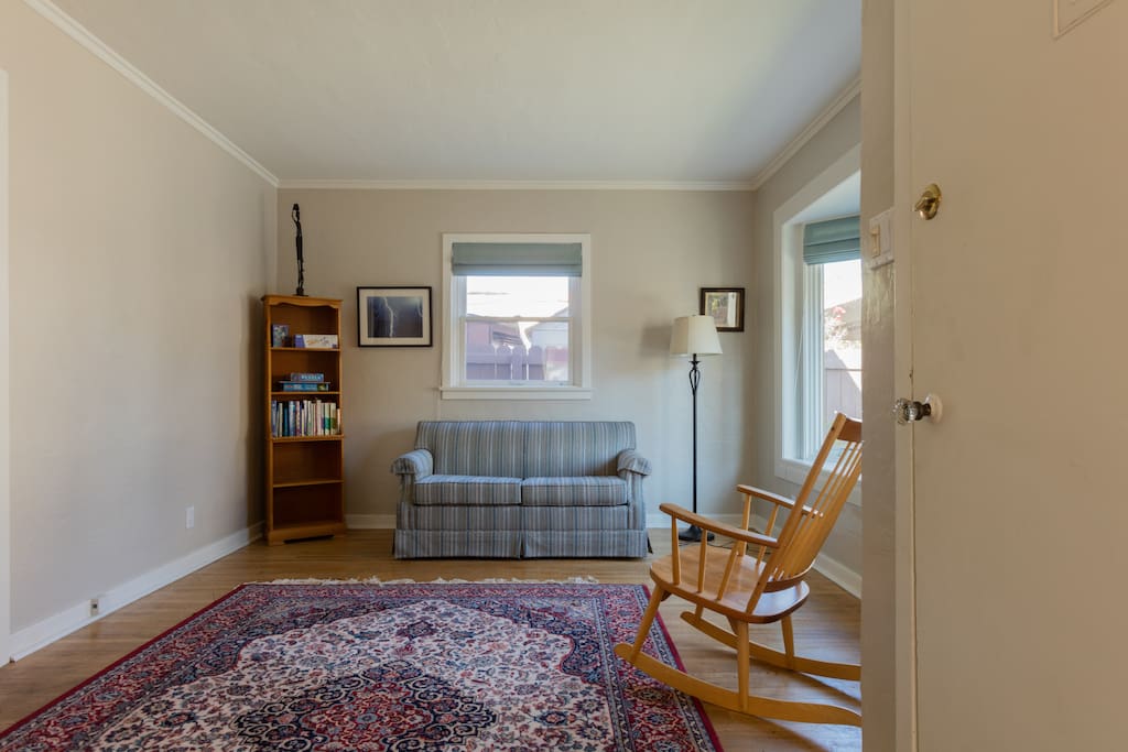 Living room with twin lazy boy sofa bed, comfortable chairs and bookshelf