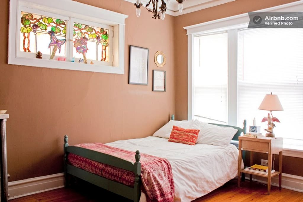 Both bedrooms offer full-sized beds with plenty of cute decorations. This one even features a stained glass window and chandelier!