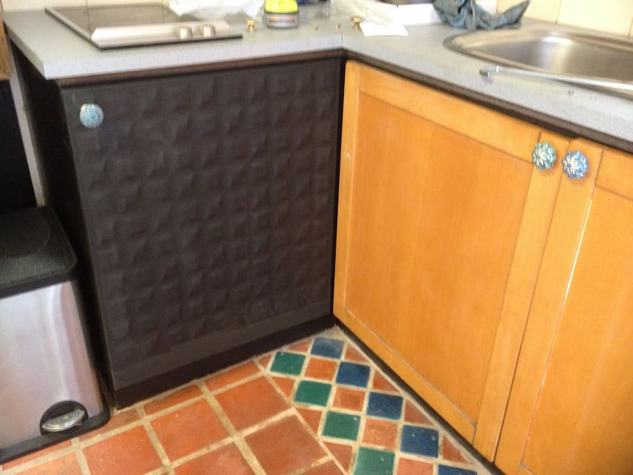 Kitchen cupboard contains microwave and little Pizza oven
