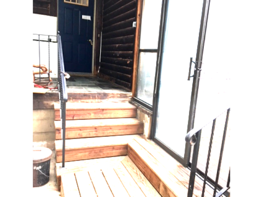 Private entrance inside the greenhouse/three-season enclosure. One step down one step up. The actual house door is not showing well but it is up the stairs to the right as you enter the greenhouse/three-season room. There is a light that is on at night.