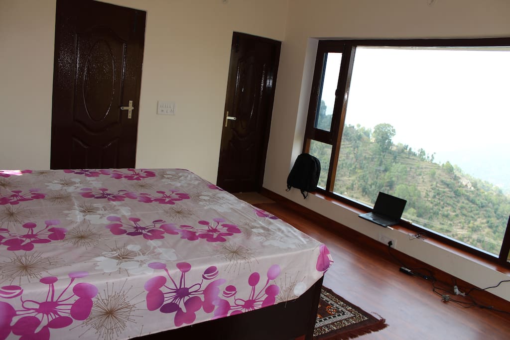 bed room with large window view upper level
