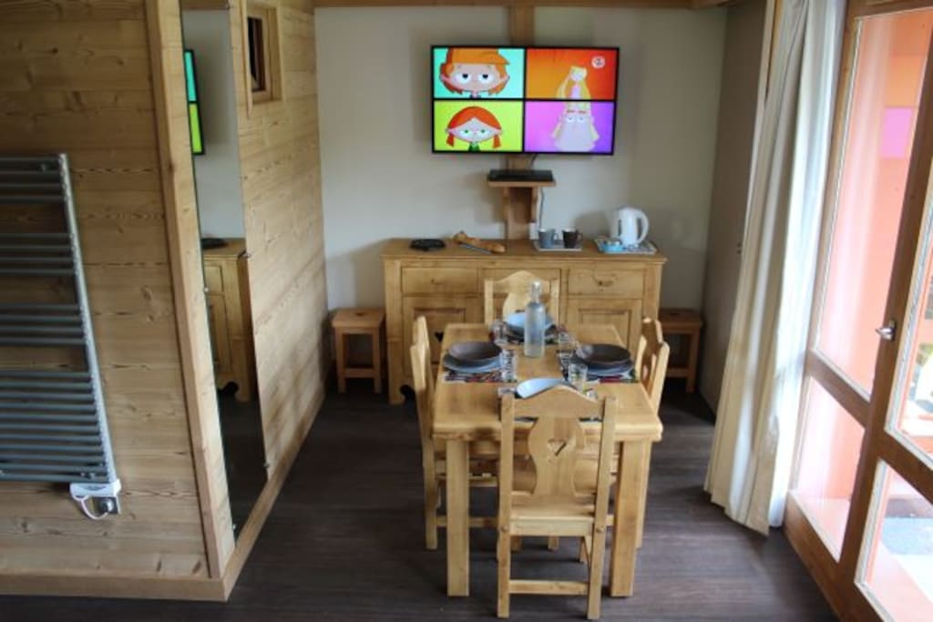 Coin repas, TV 116 cm, bahut 3 portes avec toute la vaisselle, porte-fenêtre accès direct au balcon