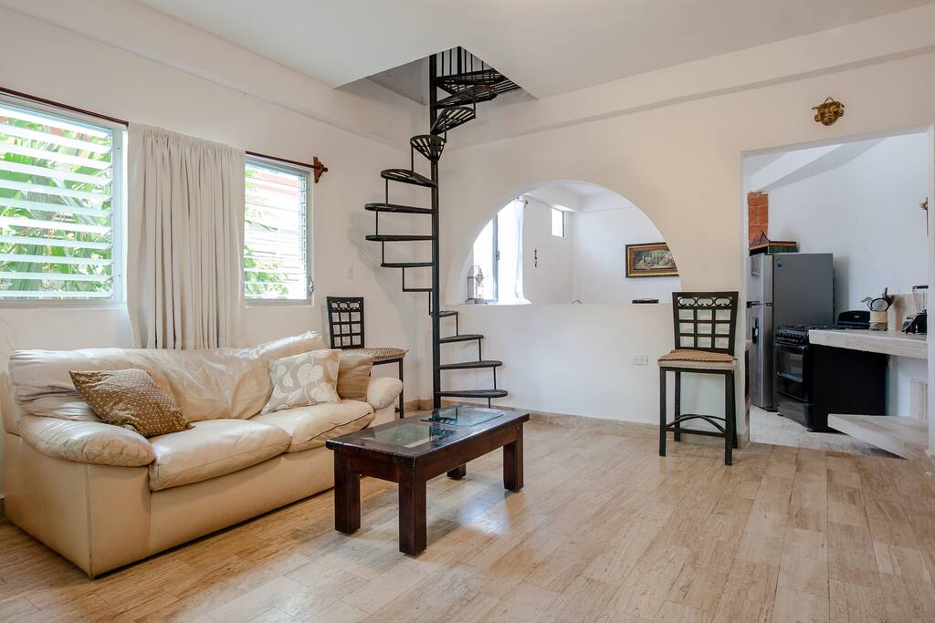 open floorplan, spiral staircase backlit at night +wrought iron closed childproof gate at top with padlock possible for small children .