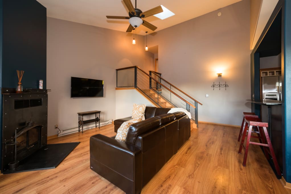 Living room on main level with TV, fireplace and balcony access.