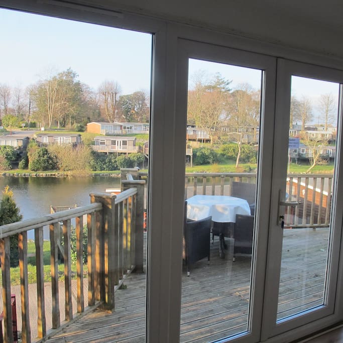 View through patio doors onto the decking - lovely outside furniture over looking the lake