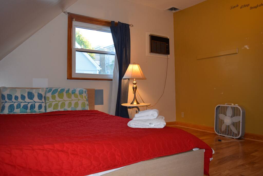 Window AC in the room, desk fan, and room darkening shades