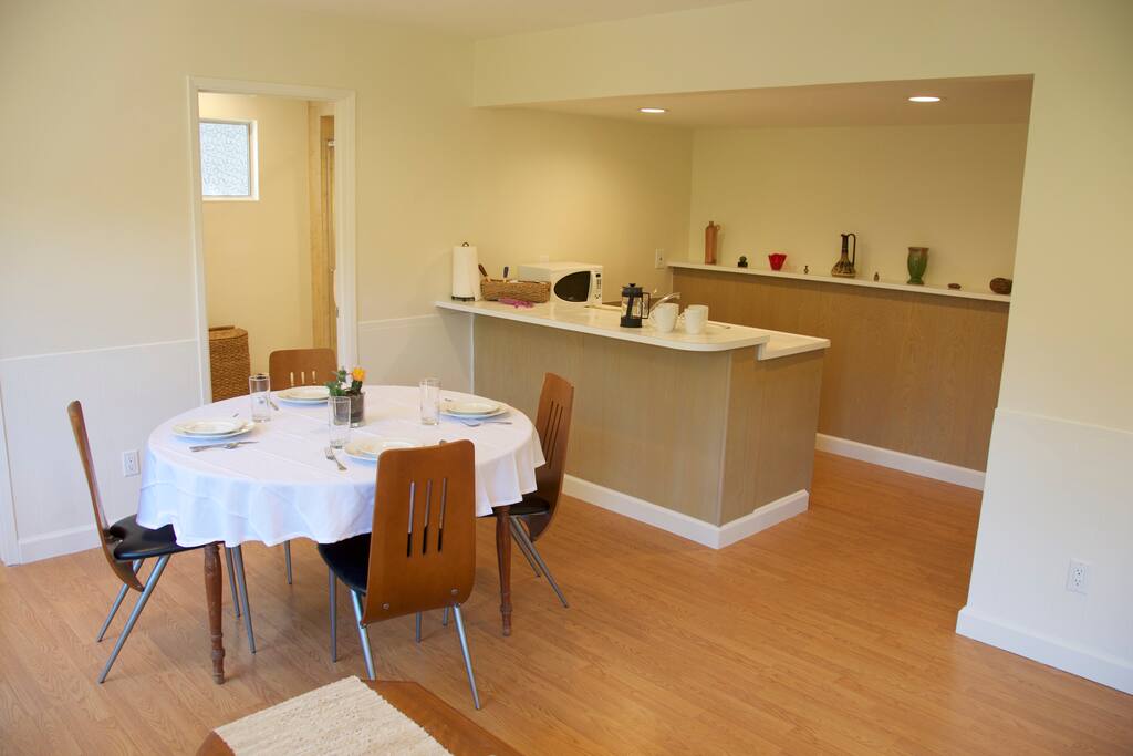 Kitchenette with sink, microwave, mini fridge, and table ware for 4 people.