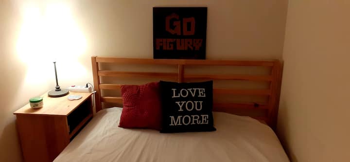 Stanza piccola e semplice con letto matrimoniale, altoparlanti e schermo HDMI.