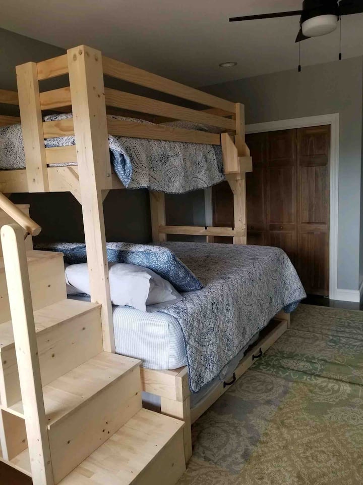 Slumber party vibes with three beds in one room (one Twin XL, one Queen, one Full)
This custom bed from College Loft Beds includes plenty of storage inside the steps and safety features such as railings on the steps and top bunk.   
