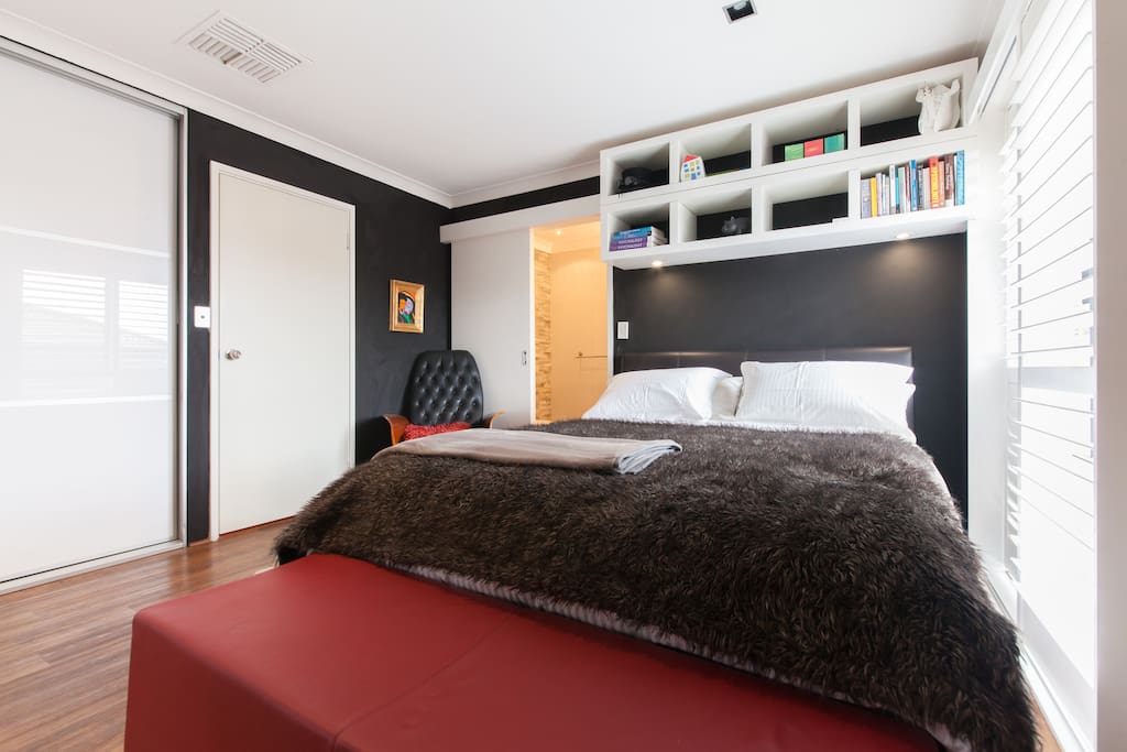 Bedroom 1, queen bed, ensuite bathroom (shower), opens to a deck and leafy private garden via glass sliding doors