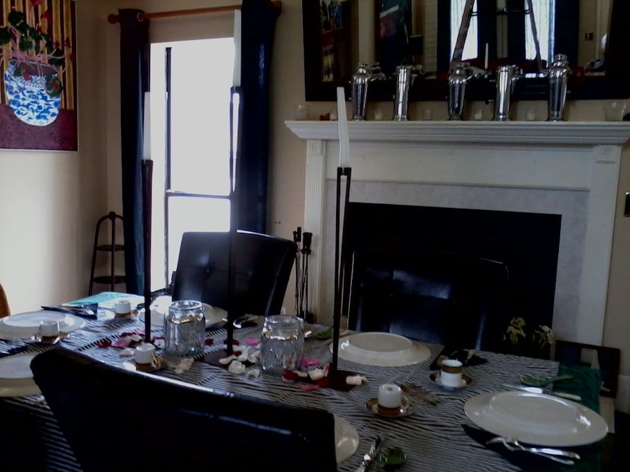 DR set up for dinner with fireplace. Art deco cocktail shakers line mantel