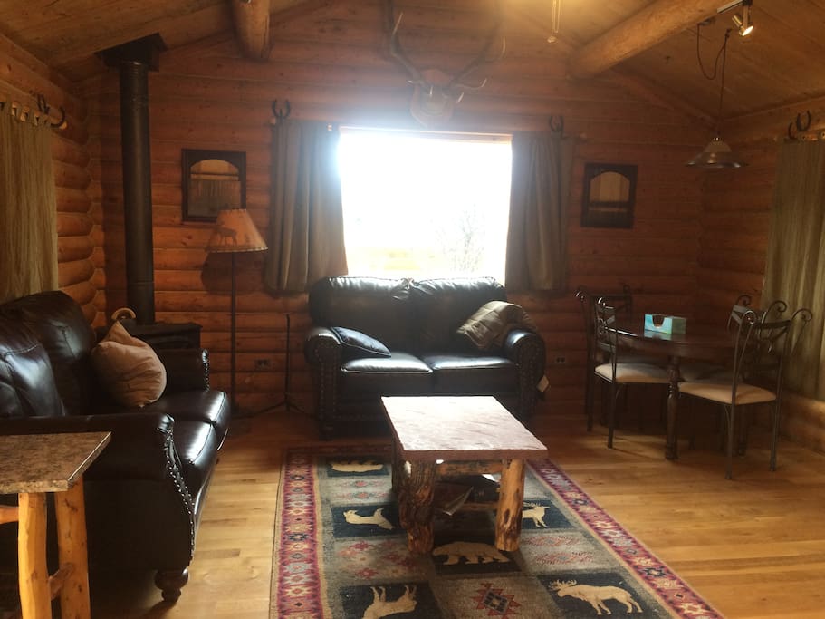 Beautiful cozy living room, custom made tables, propane fireplace, and dining table seating 4.