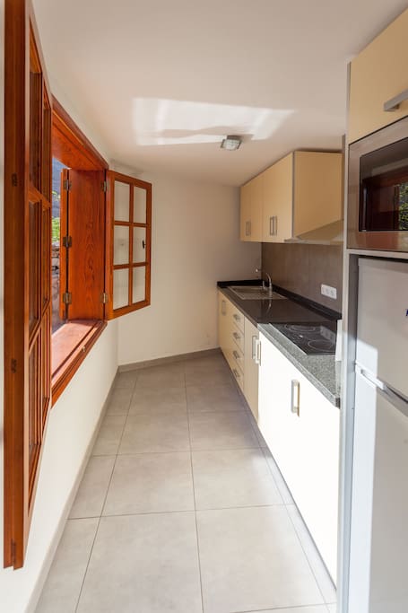 Kitchen with window to the terrace and barbecue area.