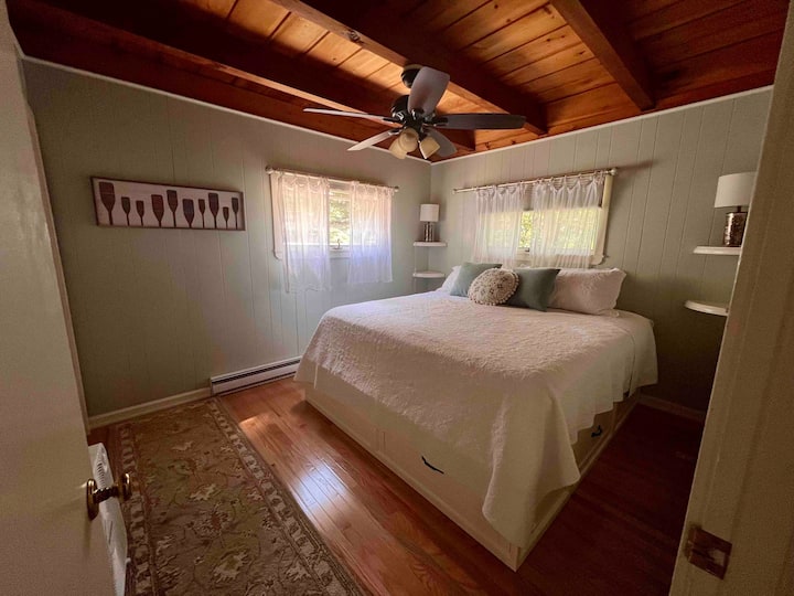 Dormitorio principal con ropa de cama cómoda y luz natural.