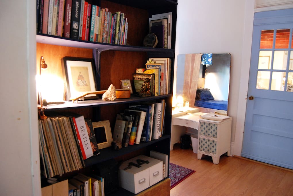 Bookshelf at the end of the bed, your vanity, and door to our loft room for rent