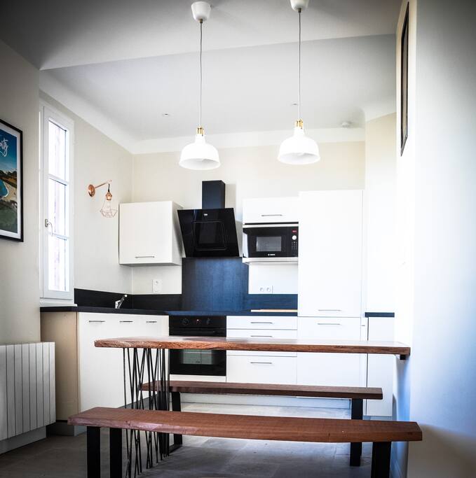 Une cuisine contemporaine et généreuse qui offre un four / micro-onde / refrigerateur-congelateur 180 L / Lave vaisselle / Plaques induction