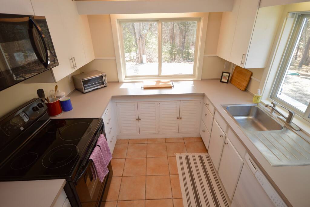 Kitchen with lots of light- stove, toaster, microwave, dishwasher