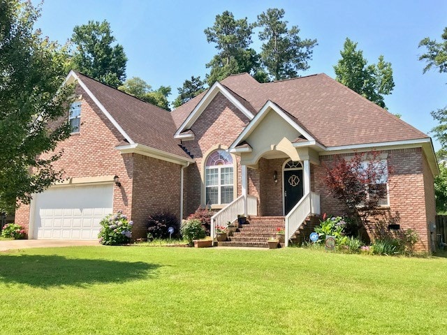 A charming brick house features a well-maintained front yard with lush green grass. The inviting entrance is accentuated by a covered porch and a set of steps leading to double doors. Tall trees surround the property, creating a tranquil environment.