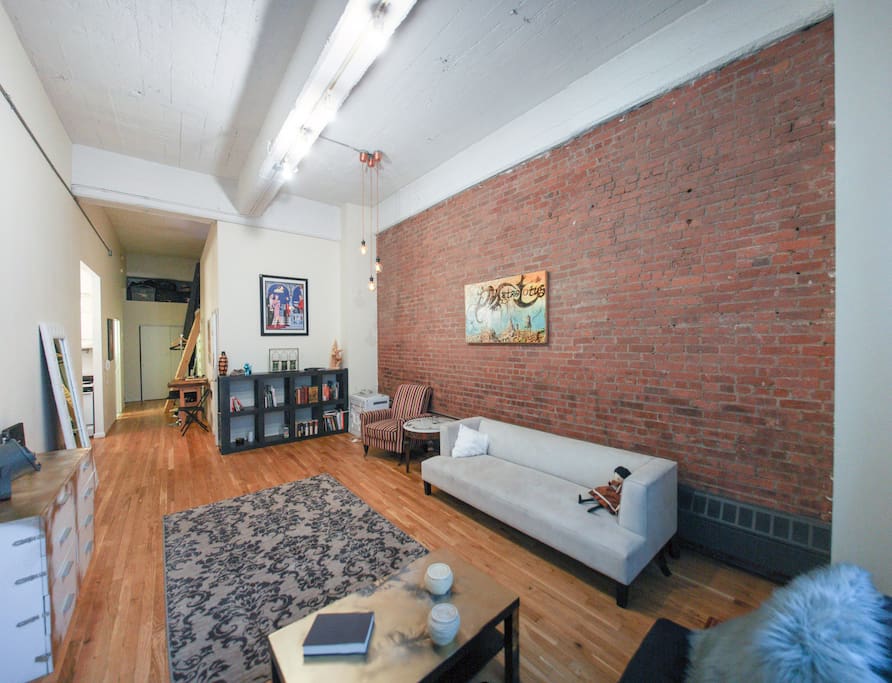 Living room and hallway, showing the stairs leading up to the lofted bedroom .