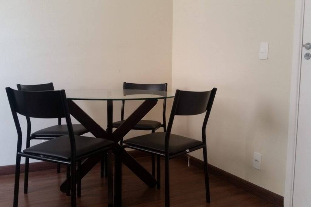 A mesa está próxima à entrada da cozinha, ideal para tomar seu café da manhã