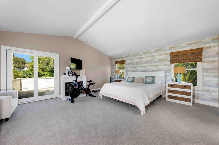 Dormitorio principal con cama California King, bicicleta de pelotón y vista al mar. 