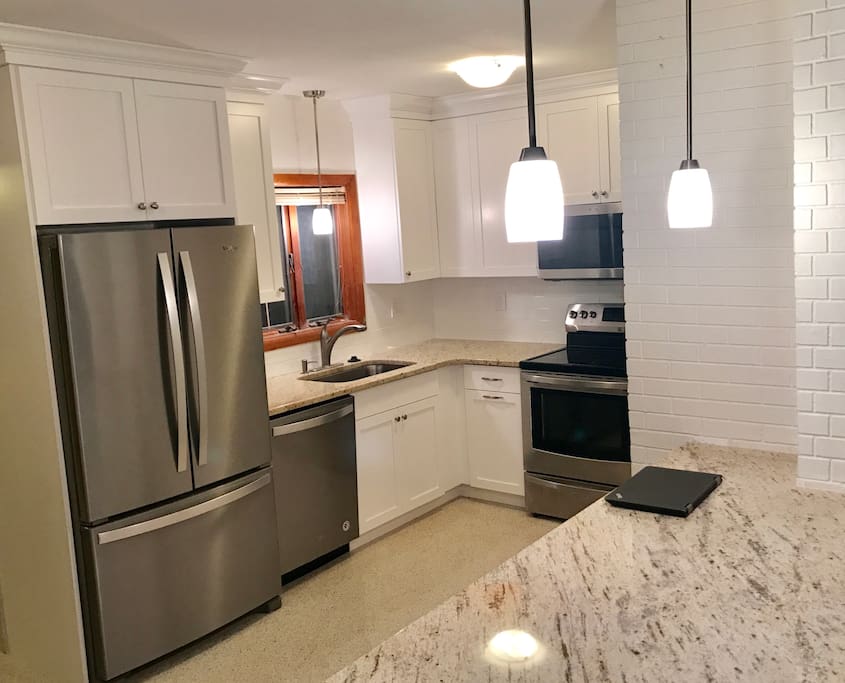 Remodeled kitchen with Shaker style wood cabinets, stainless steel appliances and granite counters