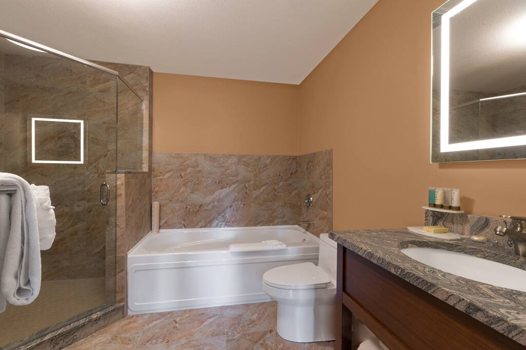 The spacious bathroom is pristine and clean.
