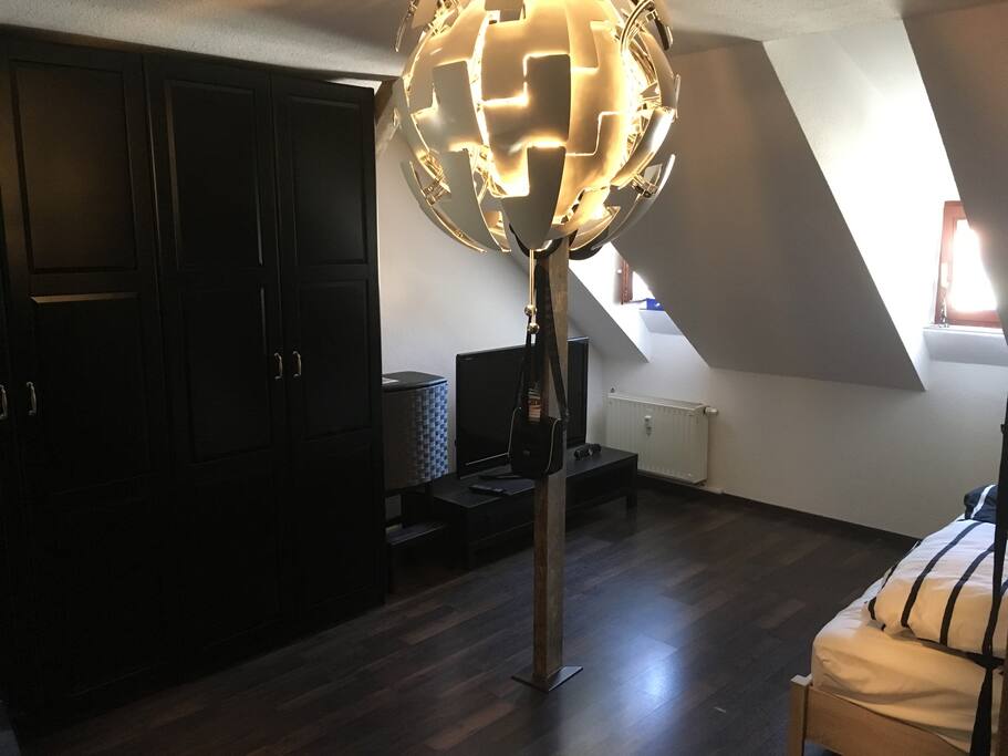 Schlafzimmer mit TV, Spiegel, Steckdosen direkt neben dem Bett, Schrank mit Hänge- und Liegemöglichkeiten als auch Verdunklungsrollos.