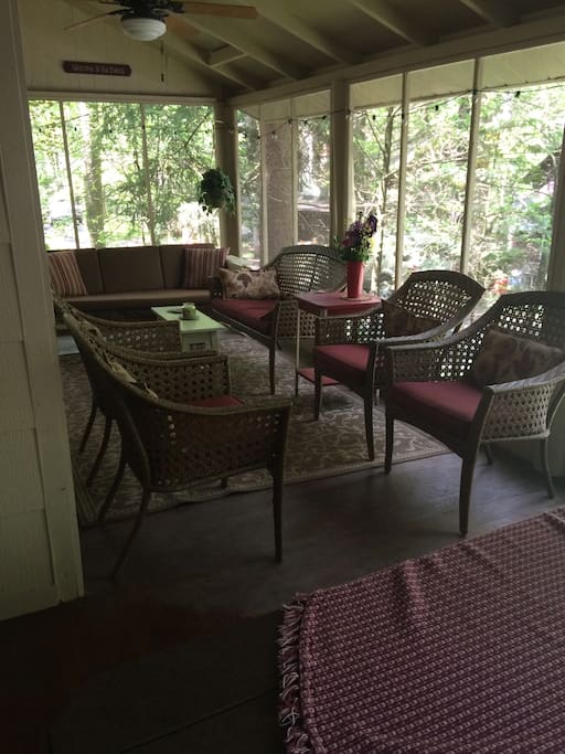 Screened in porch with table and sitting area