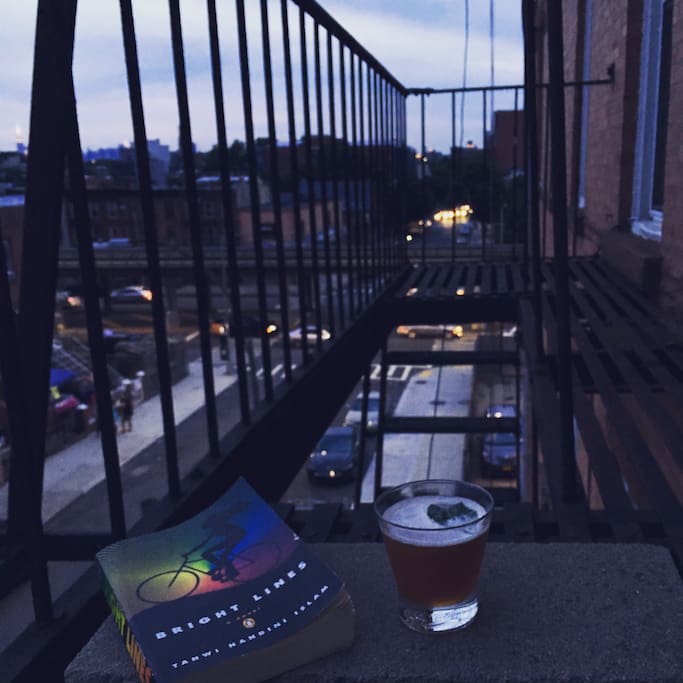 Relax on the fire escape with sunset views, cocktail and a book