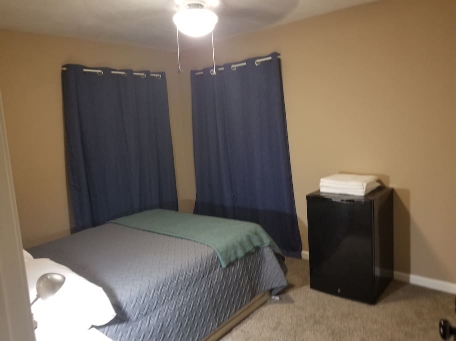 Simple room that offers a place to sleep, a mini fridge for personal use, and a locking door.