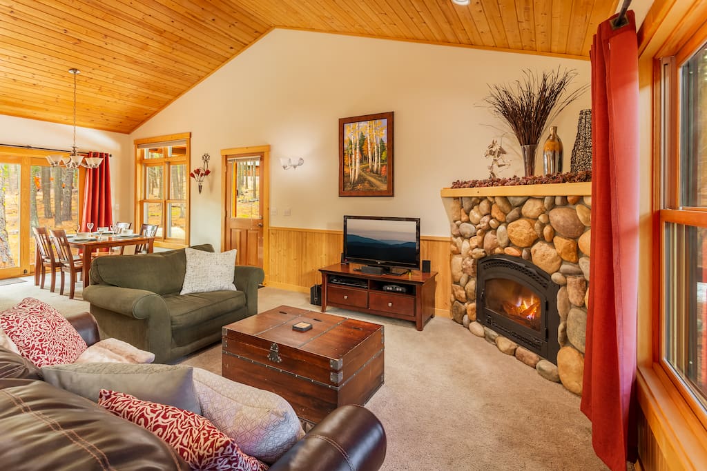 Large, open living room with high ceiling, sleeper sofa and gas fireplace