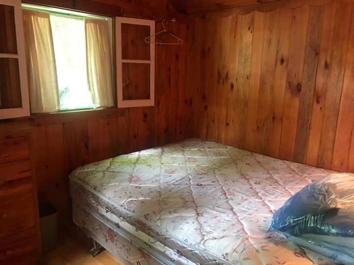 Dormitorio con cama tamaño queen. 2 ventanas y un aparador. 