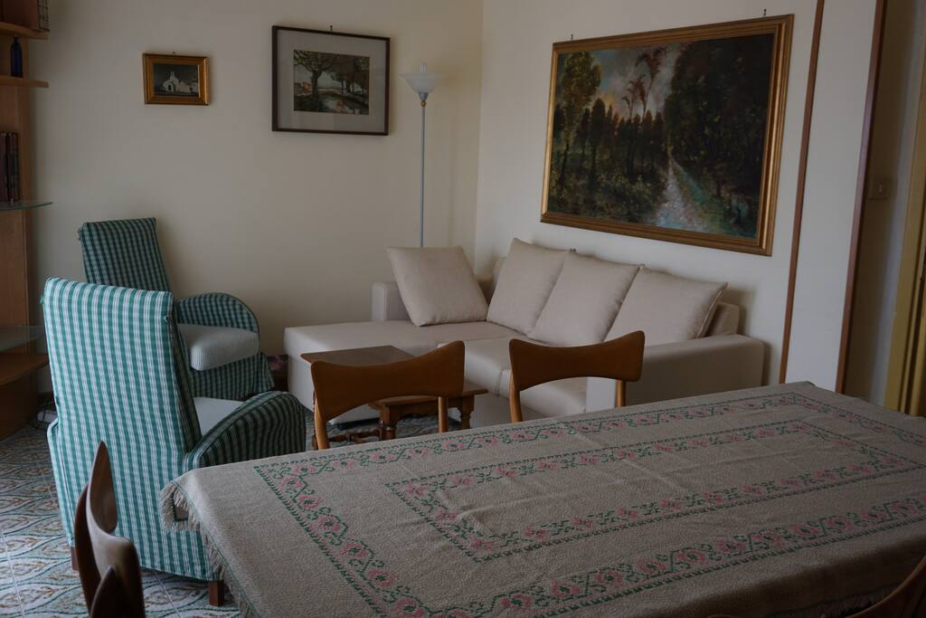 Salotto con televisione, sala pranzo e balconcino