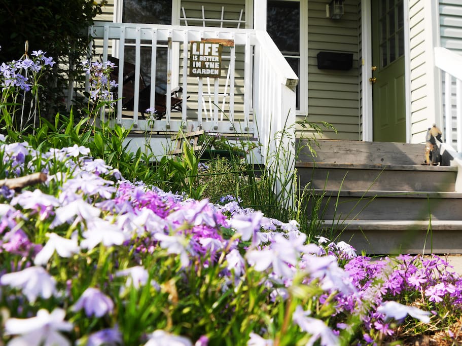Porch overlooks a beautiful garden of flowers in the warm months