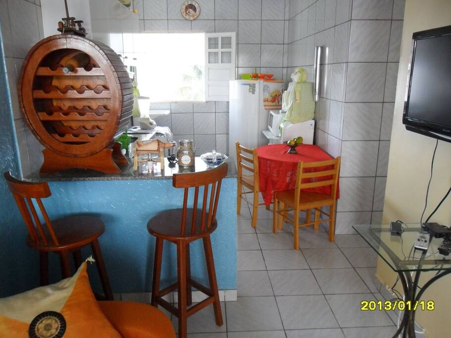 Foto da sala de estar e cozinha: bastante iluminada, ventilada e com grande quantidade de mobília para maior comodidade dos hóspedes.