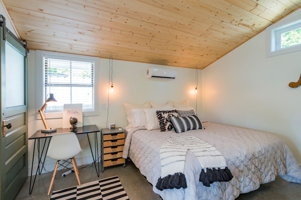 King bed and remote controlled Heat/AC unit under pine ceilings and finished concrete floors.