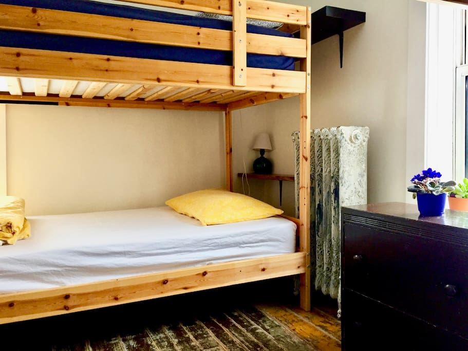 Shared 4-bed dorm with area lamps & shelf for each bunk