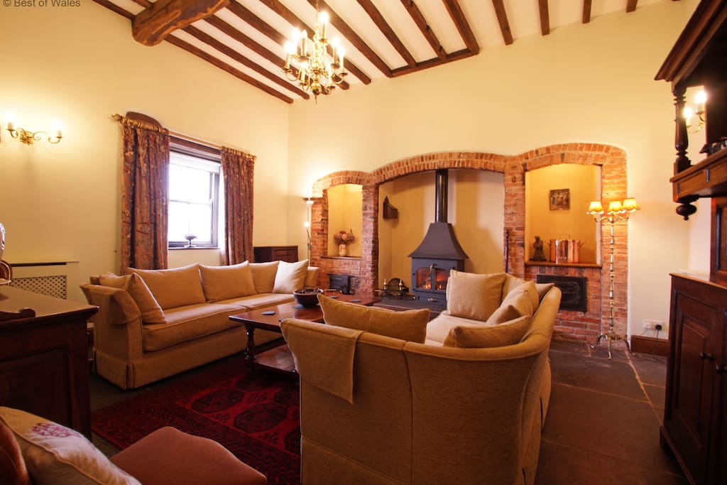 Spacious lounge with welcoming woodburner, rugs and large comfy sofas