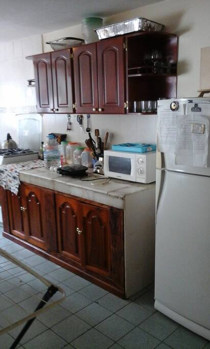 Amplia cocina con mobiliario: refrigeradora, microhondas, lavadora