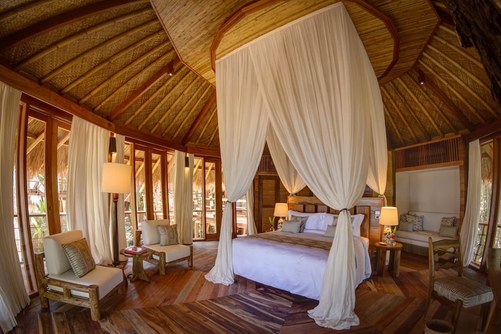 A Sumba-chic bedroom with traditional thatched roof