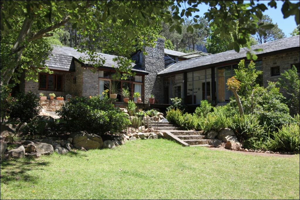 A magnificent house surrounded by lush garden and forest