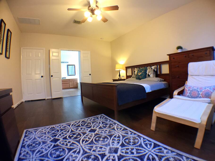 King size bed and comfortable chair. The large bathroom inside the suite