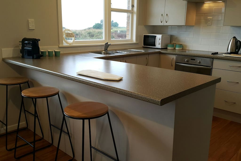 Modern kitchen, stainless appliances (double-door fridge, dishwasher, oven), microwave and Nespresso all with stunning sea views