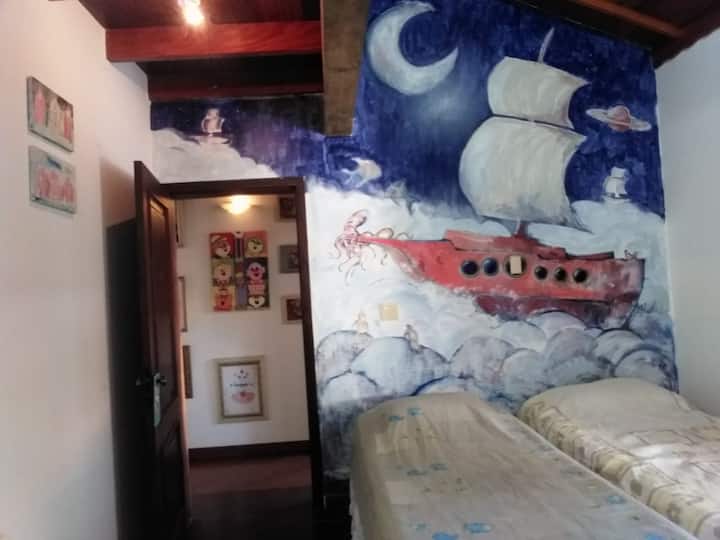 Dhoma e gjumit 3 - Dy krevate tek. Dy gardëroba. Piktura murin e artistit dhe ilustruesit Eduardo Nunes.