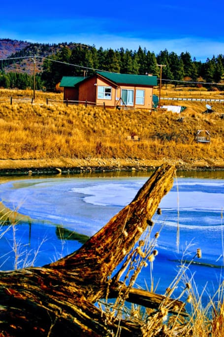 View of cabin from path around peaceful Song Spring Lake