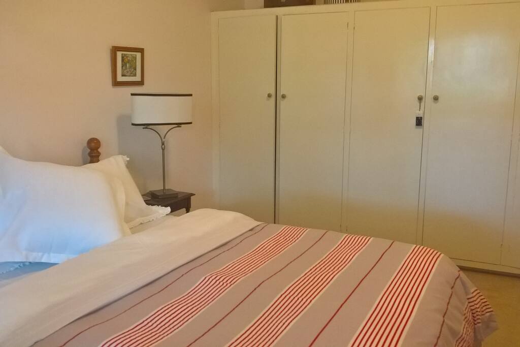 Spacious Queen bedroom with wardrobe, couch and armchair