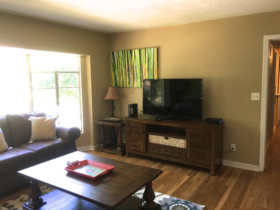 Comfortable living area with 50" television and bay window that overlooks a peaceful pond.