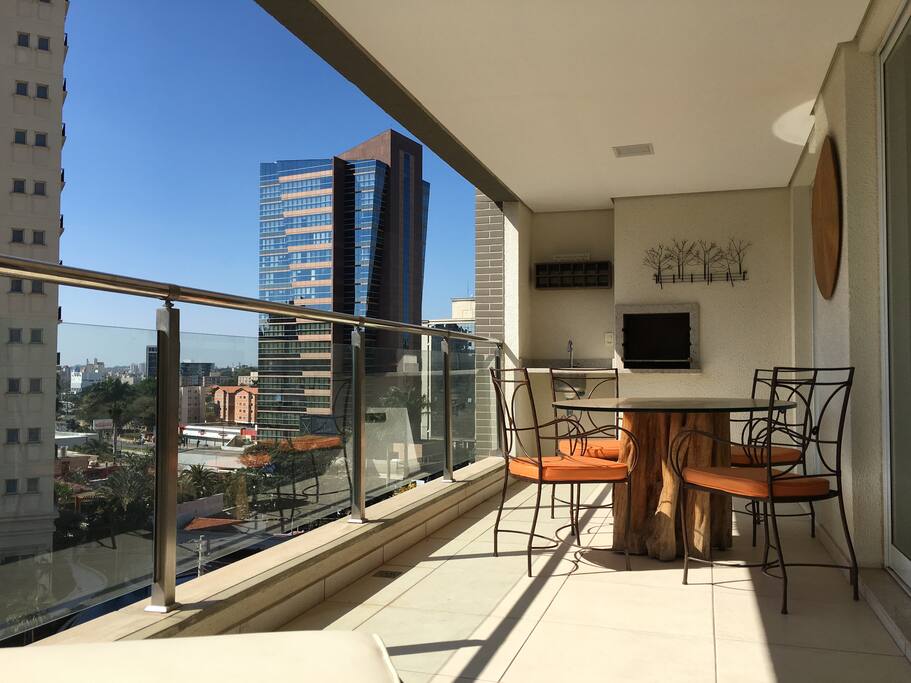 Sacada do apartamento com churrasqueira, acesso a sala de jantar, living e cozinha