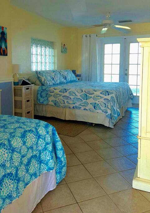 Bedroom with king and day bed. Tv in bedroom. Estero bay can be seen from the room. French doors lead to screened porch